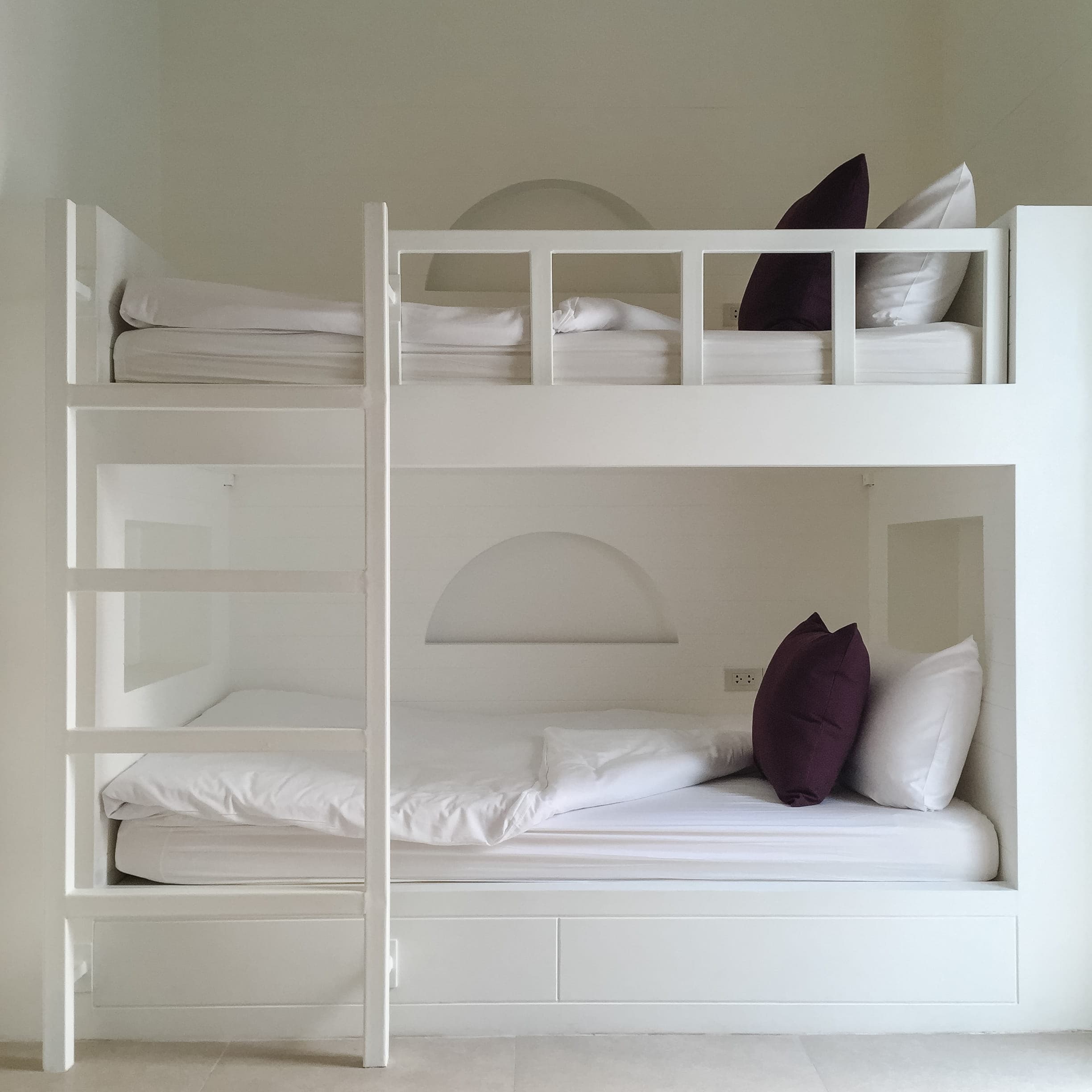 Built-in white kids bunk beds with ladder and under-bed storage